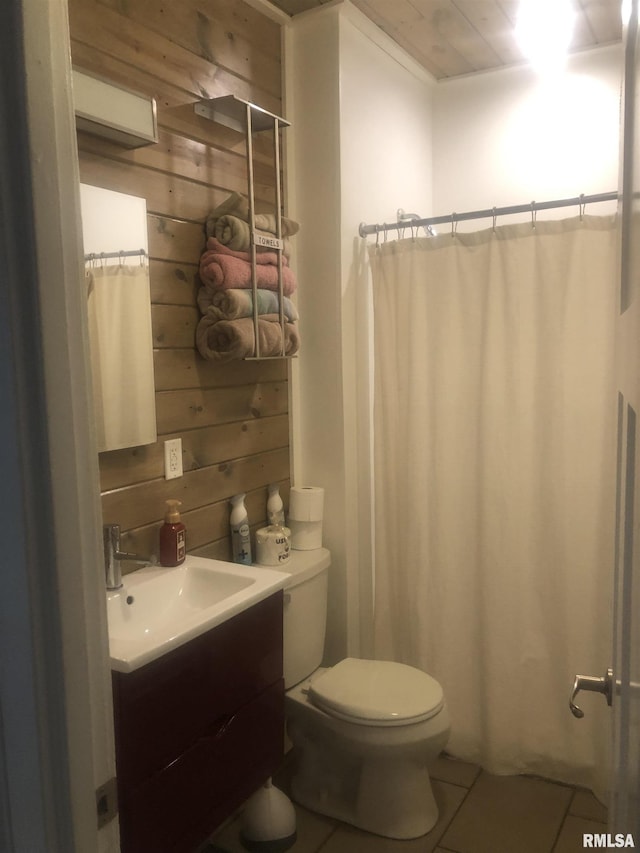 bathroom featuring wood walls, tile patterned flooring, vanity, toilet, and a shower with curtain