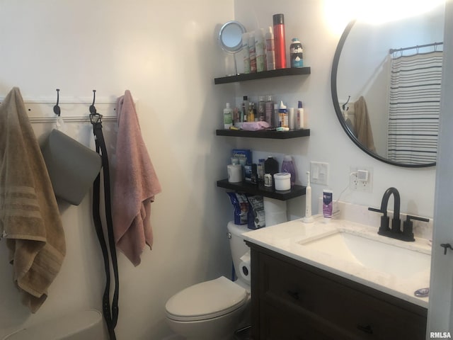 bathroom with vanity, curtained shower, and toilet