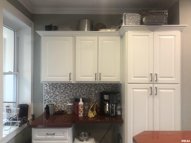 kitchen with white cabinetry, backsplash, and crown molding