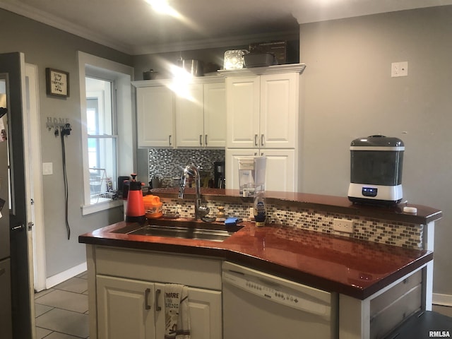 kitchen with sink, white cabinetry, tile patterned flooring, backsplash, and white dishwasher