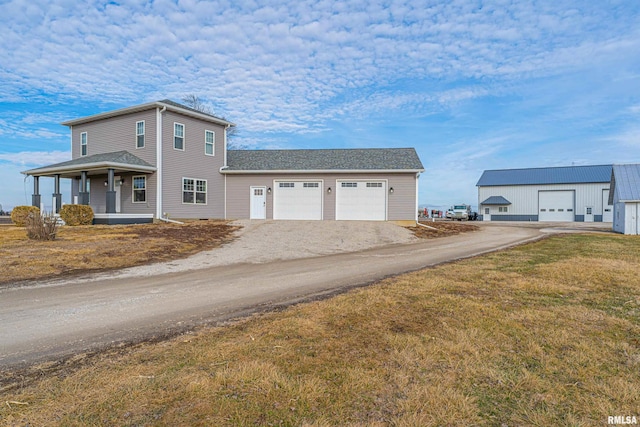 view of front of property featuring a porch, a garage, and a front yard