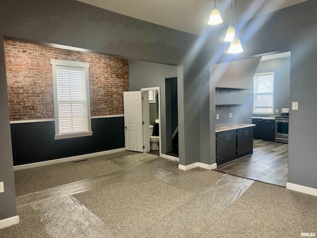 unfurnished room featuring brick wall