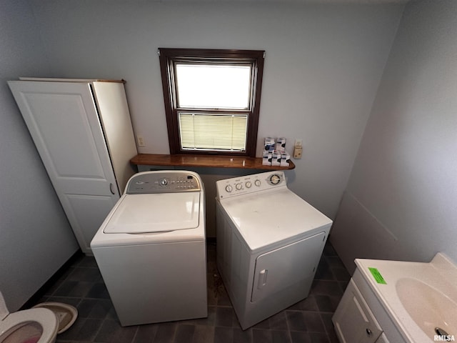 laundry area with sink, dark tile patterned flooring, and washing machine and dryer