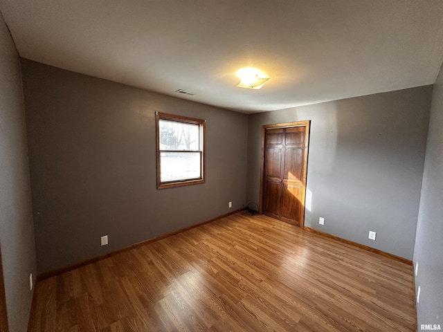 unfurnished bedroom featuring hardwood / wood-style floors and a closet