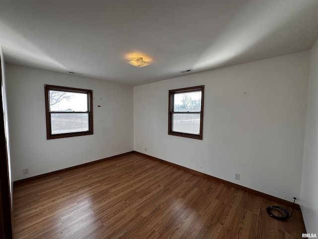 unfurnished room featuring wood-type flooring and a wealth of natural light