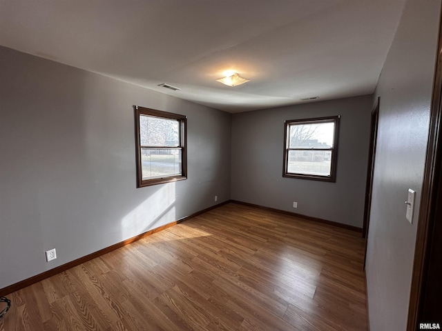 unfurnished room featuring a healthy amount of sunlight and hardwood / wood-style floors