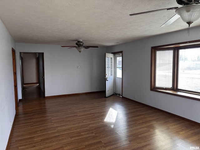 unfurnished room with dark hardwood / wood-style flooring, a textured ceiling, plenty of natural light, and ceiling fan