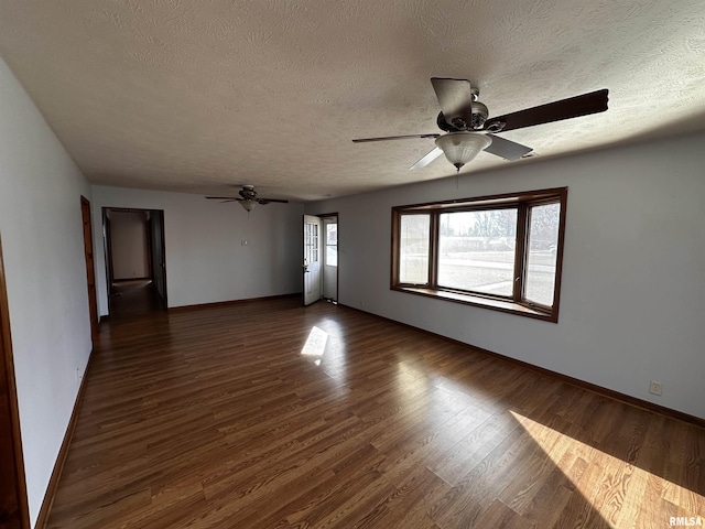 unfurnished room featuring a textured ceiling, dark hardwood / wood-style floors, and ceiling fan