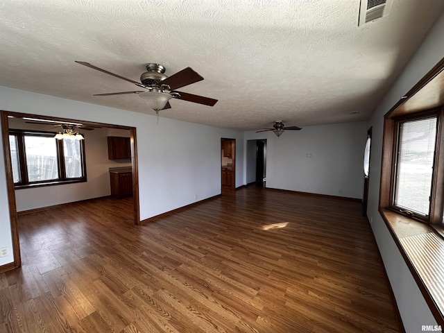 unfurnished room with dark wood-type flooring, ceiling fan, and a textured ceiling