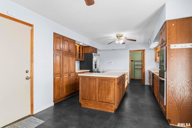 kitchen with stainless steel appliances, a center island, and ceiling fan