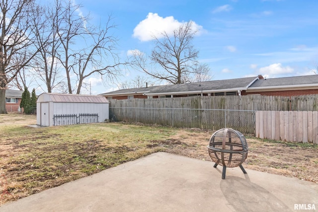 view of yard featuring a storage shed, a patio, and an outdoor fire pit