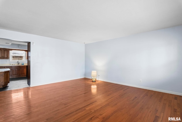 spare room with light hardwood / wood-style floors and sink