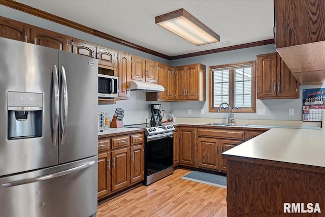 kitchen featuring appliances with stainless steel finishes, sink, ornamental molding, a textured ceiling, and light hardwood / wood-style flooring