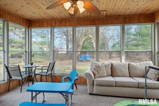 sunroom / solarium featuring ceiling fan, a wealth of natural light, and wooden ceiling