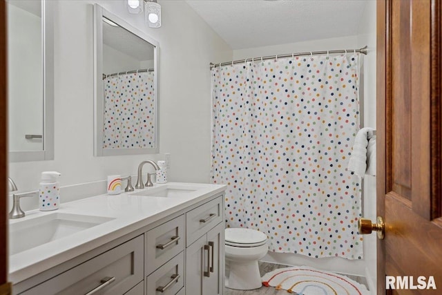 bathroom with walk in shower, vanity, toilet, and a textured ceiling