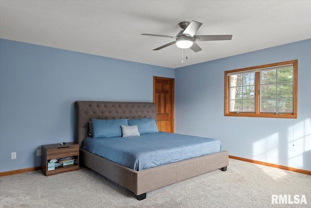 carpeted bedroom featuring a textured ceiling and ceiling fan