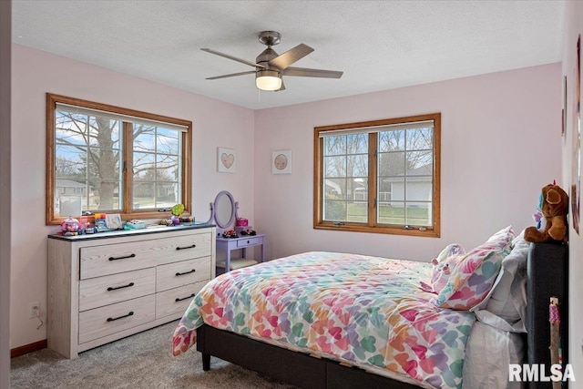 bedroom with multiple windows, ceiling fan, a textured ceiling, and carpet flooring