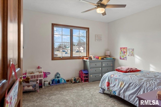 carpeted bedroom featuring ceiling fan and a textured ceiling