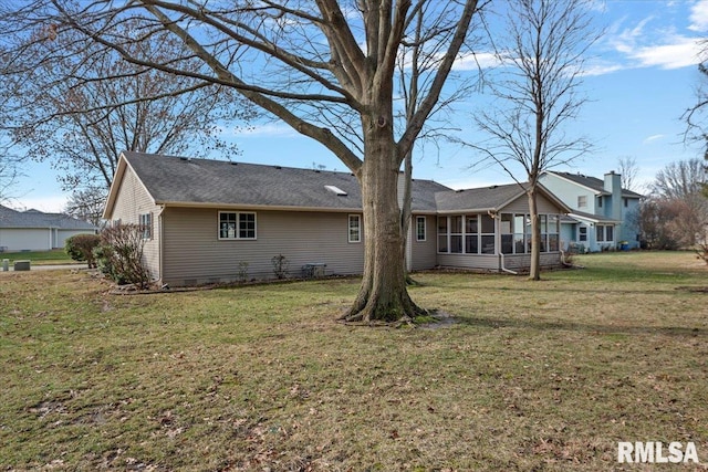 back of house with a sunroom and a lawn