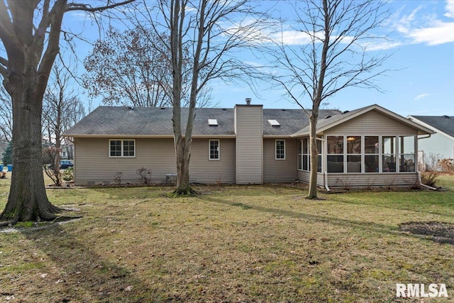 rear view of property featuring a yard and a sunroom