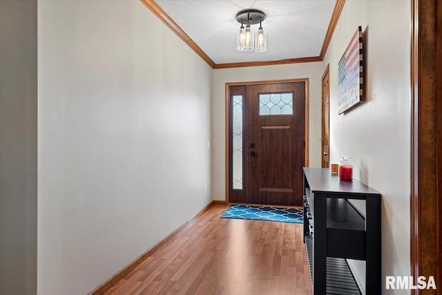 foyer with ornamental molding, wood-type flooring, and a textured ceiling