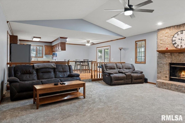 living room featuring a fireplace, vaulted ceiling, carpet, and a wealth of natural light