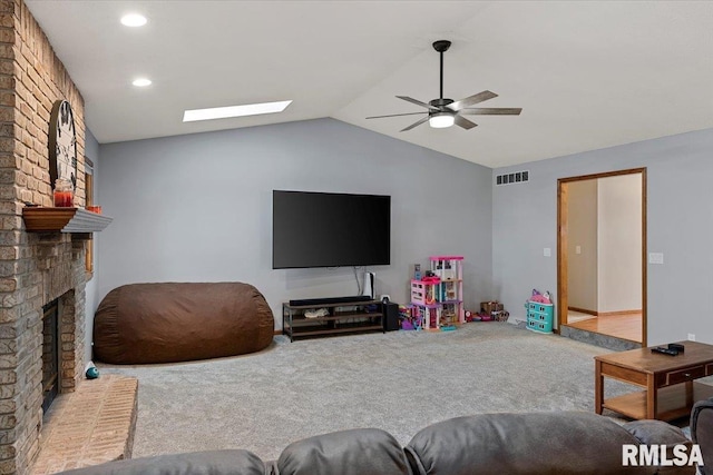 living room with vaulted ceiling, carpet, ceiling fan, and a brick fireplace