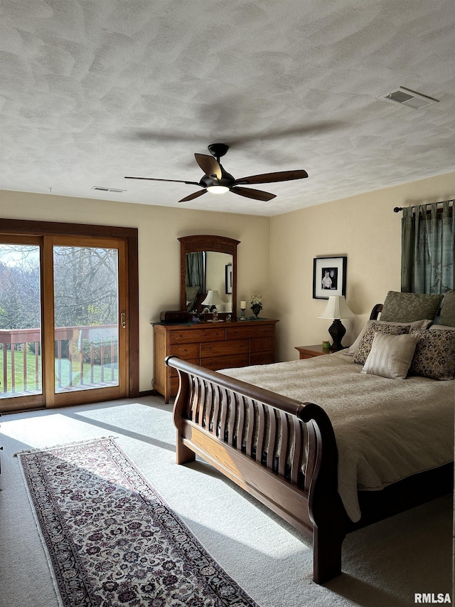 bedroom featuring ceiling fan, carpet floors, access to outside, and a textured ceiling