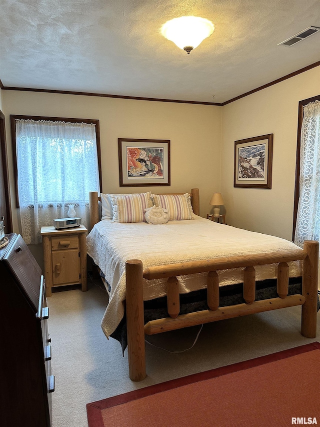 bedroom featuring crown molding, carpet flooring, and a textured ceiling