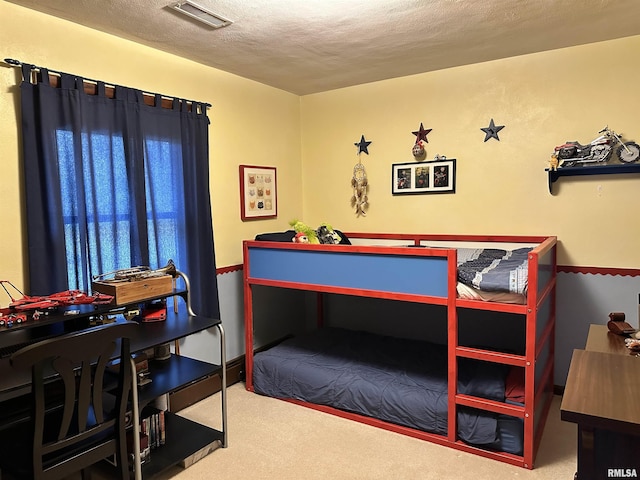 carpeted bedroom featuring a textured ceiling and visible vents