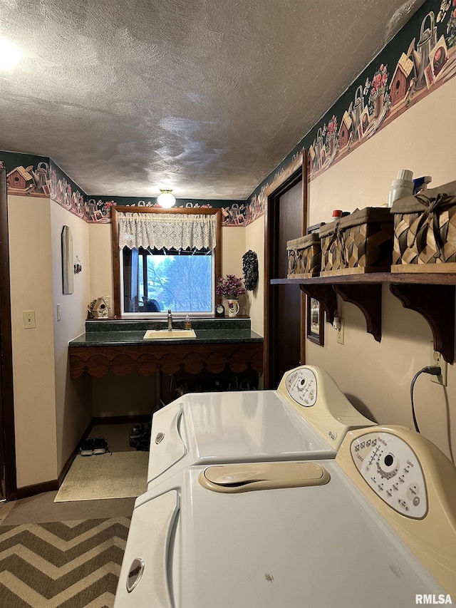 clothes washing area featuring carpet, sink, washer and dryer, and a textured ceiling