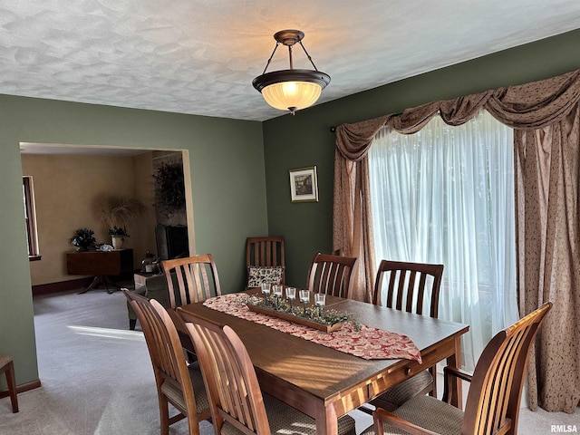 carpeted dining space featuring a textured ceiling