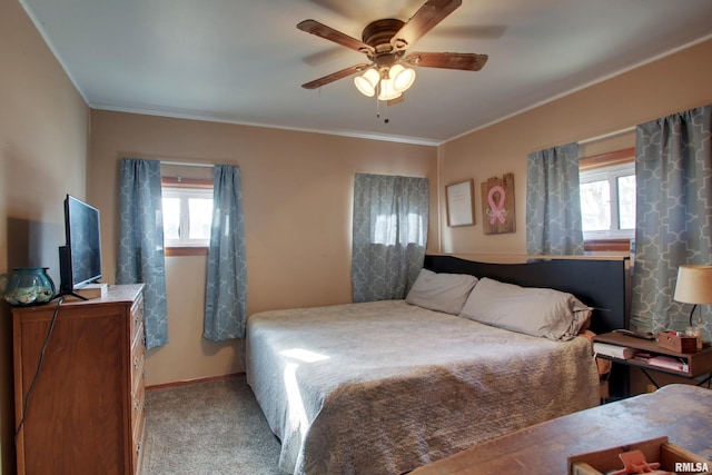 bedroom featuring multiple windows, ornamental molding, light colored carpet, and ceiling fan