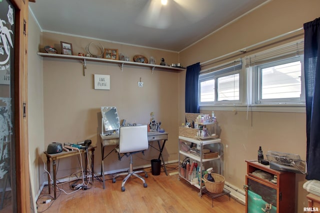 home office with ornamental molding and light hardwood / wood-style flooring