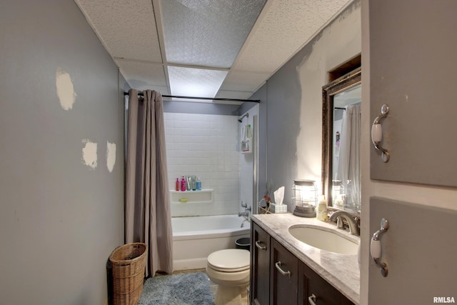 full bathroom featuring shower / tub combo with curtain, vanity, toilet, and a drop ceiling