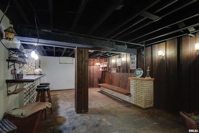 basement with wooden walls and bar area