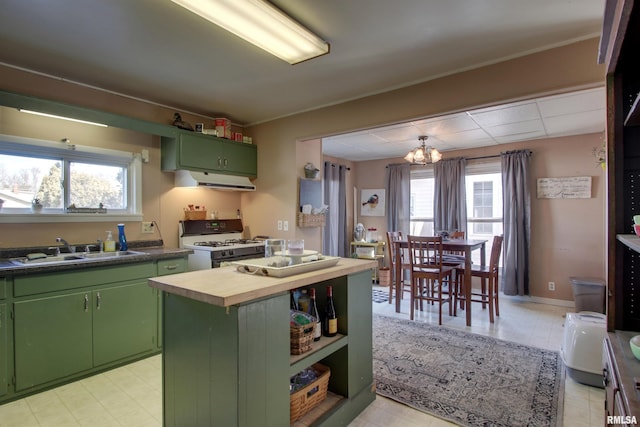 kitchen with butcher block counters, sink, a center island, green cabinets, and white gas range oven