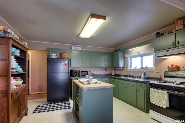 kitchen featuring white range with gas stovetop, green cabinetry, wooden counters, black refrigerator, and a kitchen island