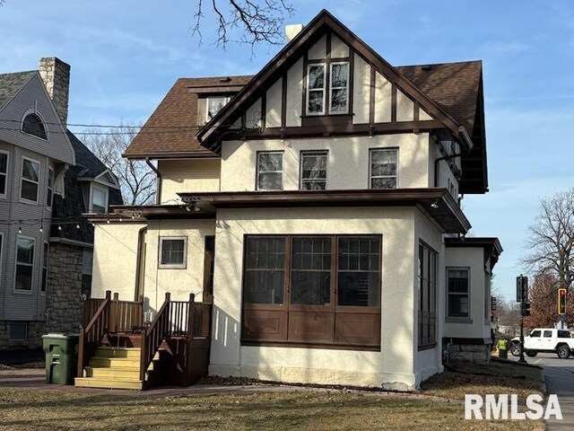 2340 Maine St, Quincy, IL 62301 - view of front of house featuring stucco siding, a front lawn, and a chimney