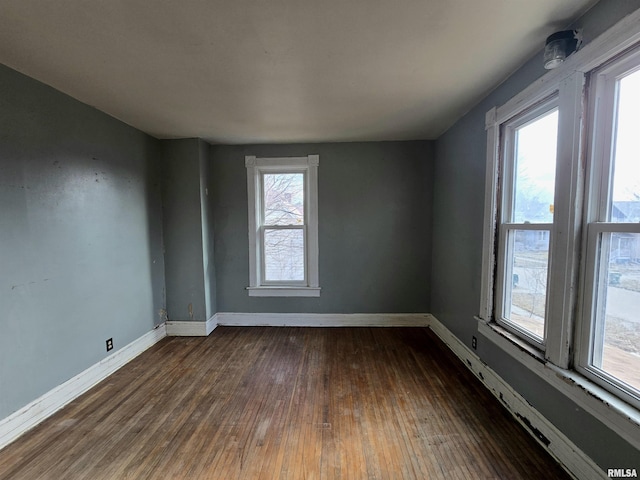 unfurnished room with dark hardwood / wood-style flooring