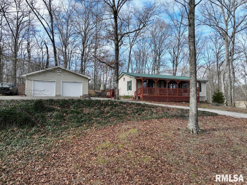 view of front of property featuring an outbuilding, a garage, and covered porch