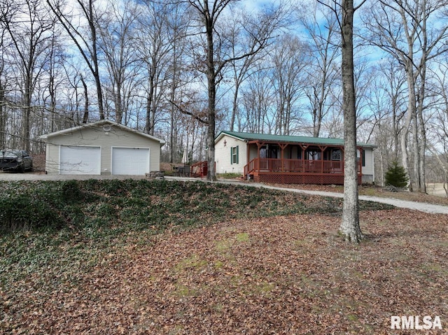 view of front of property featuring an outbuilding, a garage, and covered porch