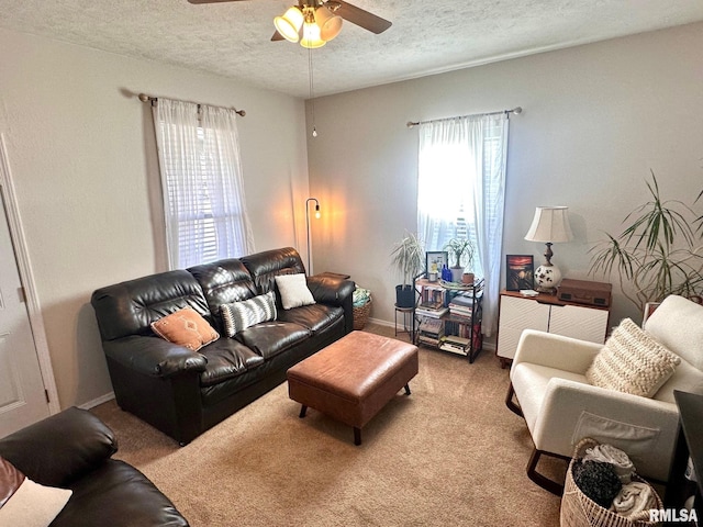 carpeted living room with ceiling fan and a textured ceiling