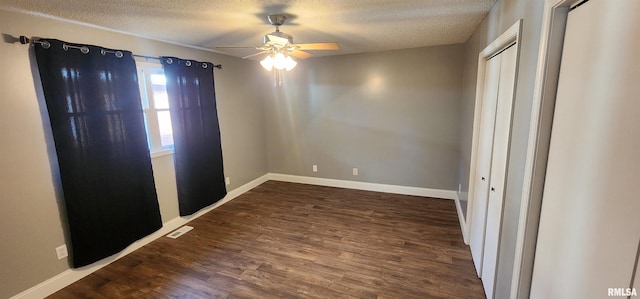 unfurnished bedroom with dark wood-type flooring, ceiling fan, a closet, and a textured ceiling