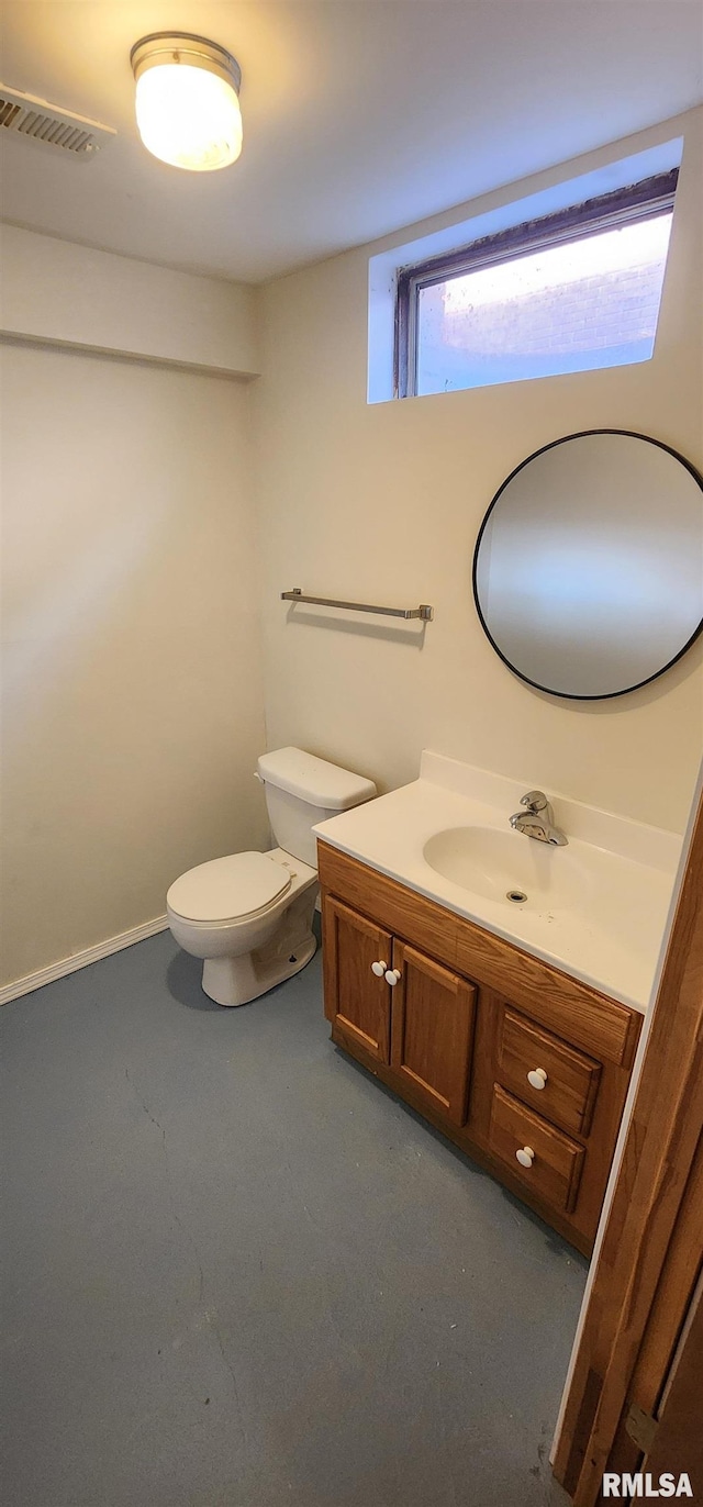 bathroom with vanity, concrete flooring, and toilet