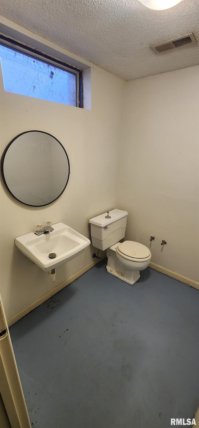 bathroom featuring sink, concrete floors, a textured ceiling, and toilet