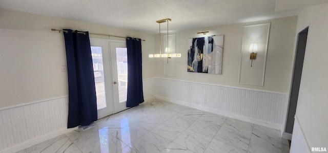 empty room with a textured ceiling and french doors