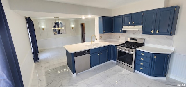 kitchen featuring appliances with stainless steel finishes, blue cabinets, sink, and kitchen peninsula