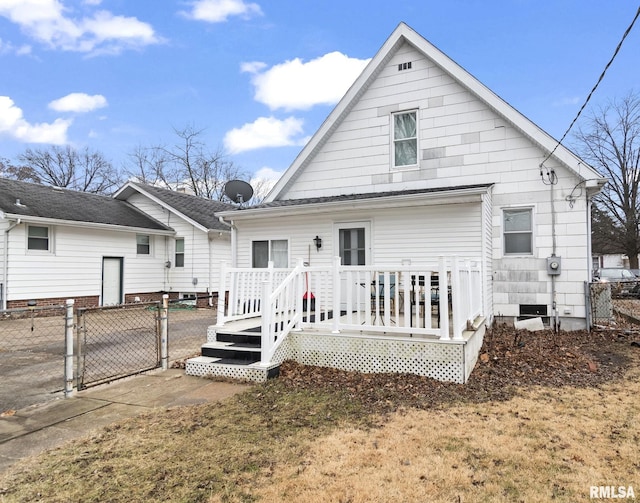 back of property with a deck and a lawn