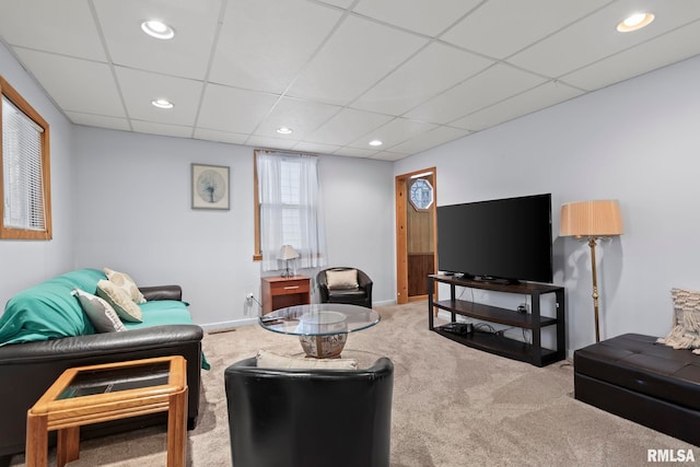 carpeted living room featuring a drop ceiling